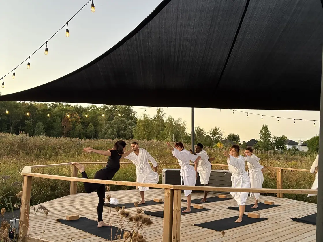 Groupe en plein cours de yoga sur une terrasse extérieure